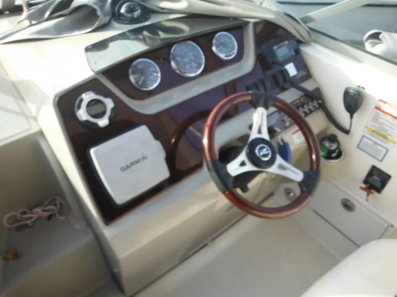 Slide: The Image of 2010 Sea Ray 260 Sundancer dashboard with Garmin GPS and wood-trimmed steering wheel. - 12