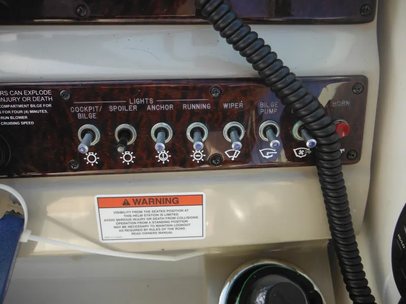 Slide: The Image of Control panel of a 2010 Sea Ray 260 Sundancer boat with various switches and warning label. - 17