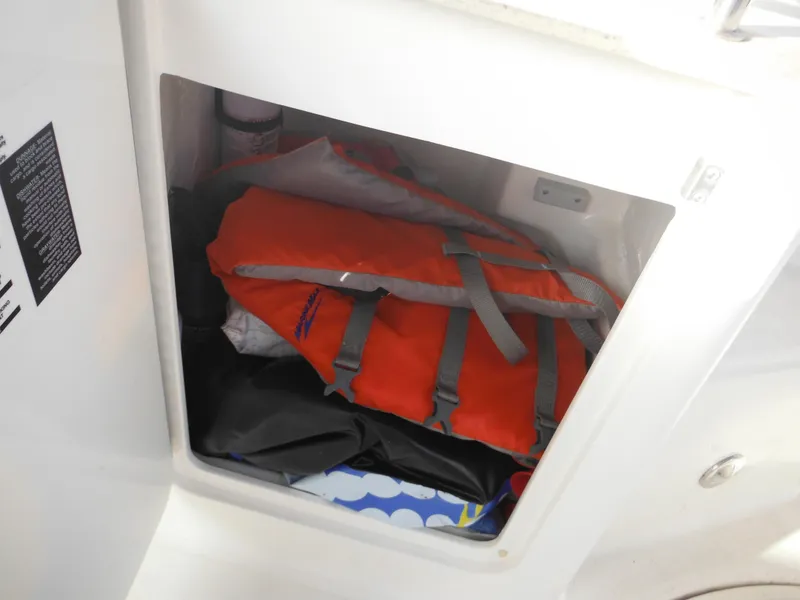 Slide: The Image of Storage compartment with life jacket on 2010 Sea Ray 260 Sundancer boat. - 27