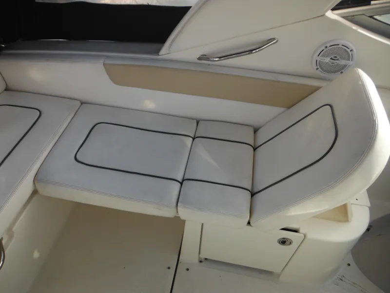 Slide: The Image of 2010 Sea Ray 260 Sundancer boat interior seating with white cushions and black trim. - 31