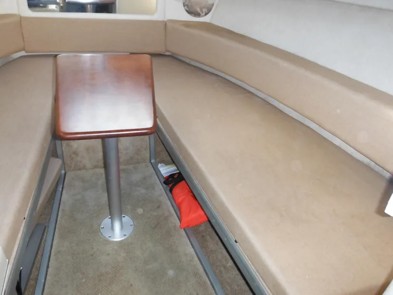 Slide: The Image of Interior of 2010 Sea Ray 260 Sundancer with beige seating and wooden table. - 35