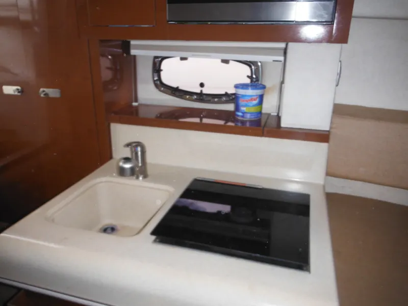 Slide: The Image of 2010 Sea Ray 260 Sundancer interior kitchen with sink and stove. - 42