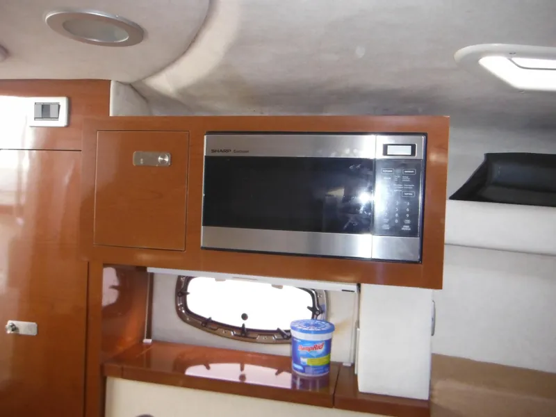 Slide: The Image of 2010 Sea Ray 260 Sundancer interior with microwave and storage cabinet. - 43