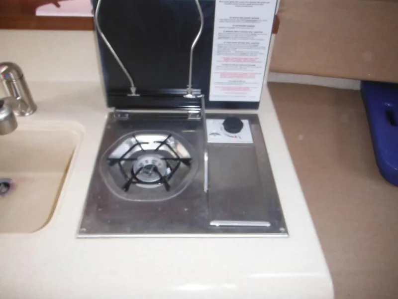 Slide: The Image of 2010 Sea Ray 260 Sundancer boat stove and sink in compact kitchen area. - 44