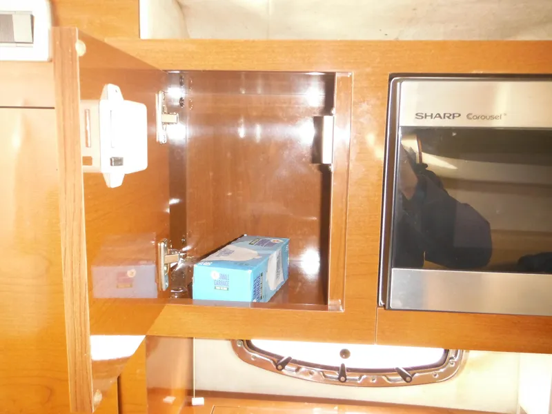 Slide: The Image of 2010 Sea Ray 260 Sundancer interior cabinet with microwave and storage space. - 45