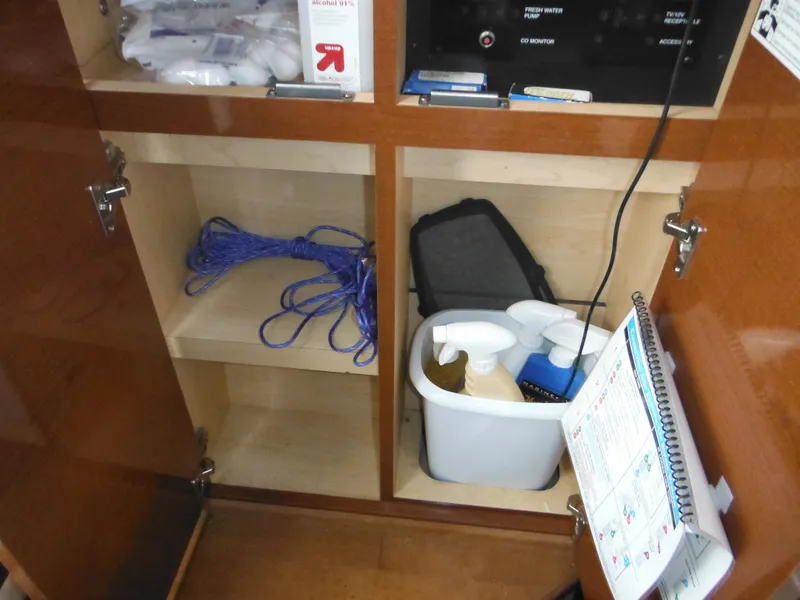 Slide: The Image of Storage cabinet in 2010 Sea Ray 260 Sundancer with cleaning supplies and rope. - 49