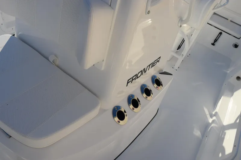 Slide: The Image of Frontier 2104 boat interior, 2025 model, featuring sleek white seating and rod holders. - 18