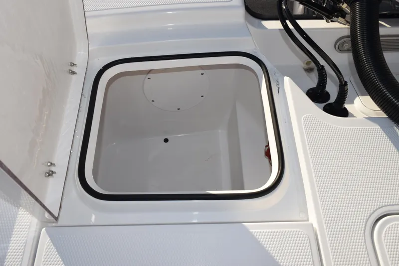Slide: The Image of Open storage compartment on a 2025 Frontier 2104 boat deck. - 26