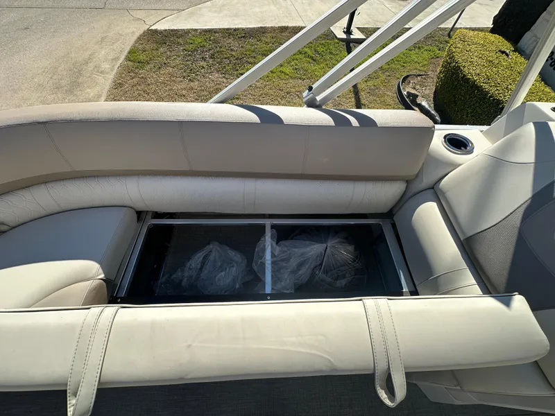 Slide: The Image of 2025 Avalon Catalina Cruise Funship 27' seating area with storage compartment. - 11