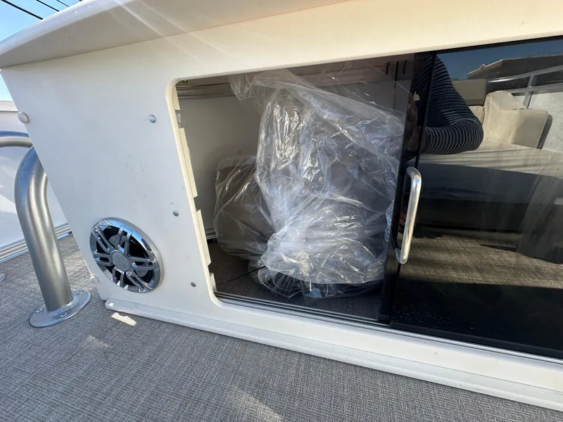 Slide: The Image of Storage compartment on 2025 Avalon Catalina Cruise Funship boat, featuring a speaker and sliding door. - 47