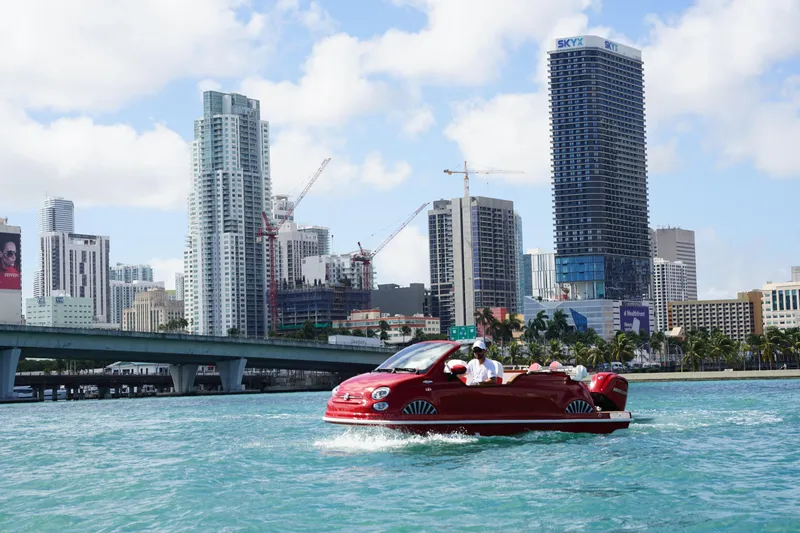 Slide: The Image of Amphibious 2025 Fiat 500 Classic navigating water with city skyline backdrop. - 20