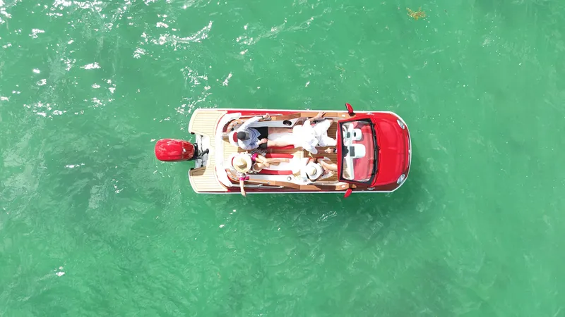 Slide: The Image of Aerial view of a 2025 Car Off-shore Fiat 500 Classic boat on turquoise water. - 7