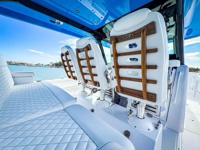 Slide: The Image of Luxurious seating on 2025 HCB 48 Campeon boat with blue canopy and ocean view. - 15