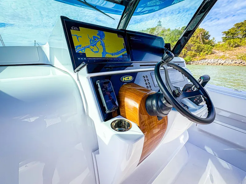 Slide: The Image of 2025 HCB 48 Campeon boat dashboard with navigation system and steering wheel. - 20