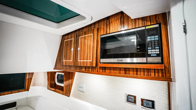 Slide: The Image of Luxurious interior of 2025 HCB 48 Campeon yacht with wood cabinetry and modern microwave. - 37