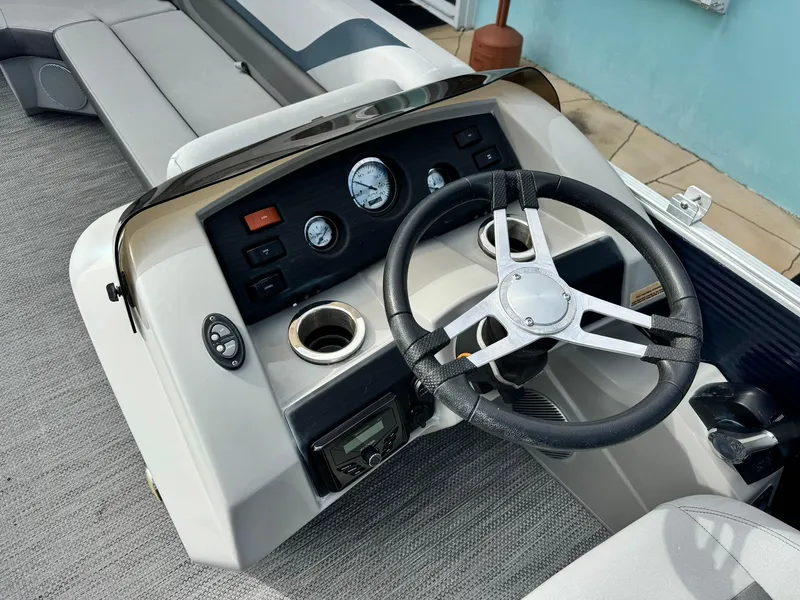 Slide: The Image of 2020 Bennington 22SSXAPG boat dashboard with steering wheel and gauges. - 12
