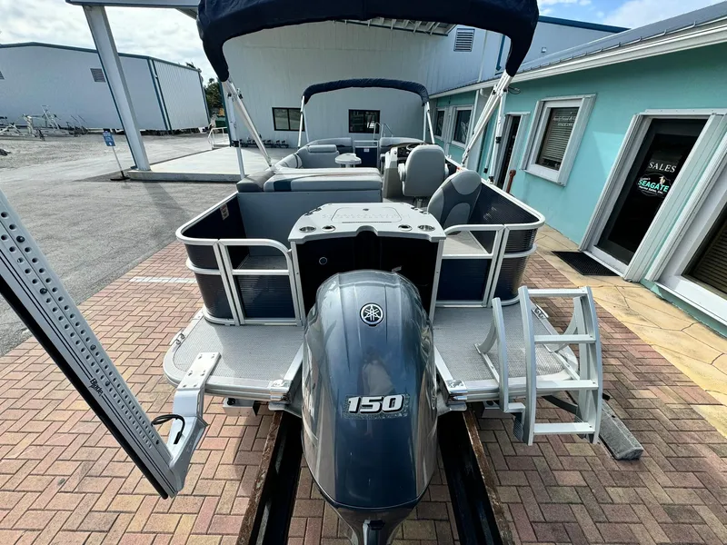 Slide: The Image of 2020 Bennington 22SSXAPG pontoon boat with Yamaha 150 engine, docked near a sales office. - 6