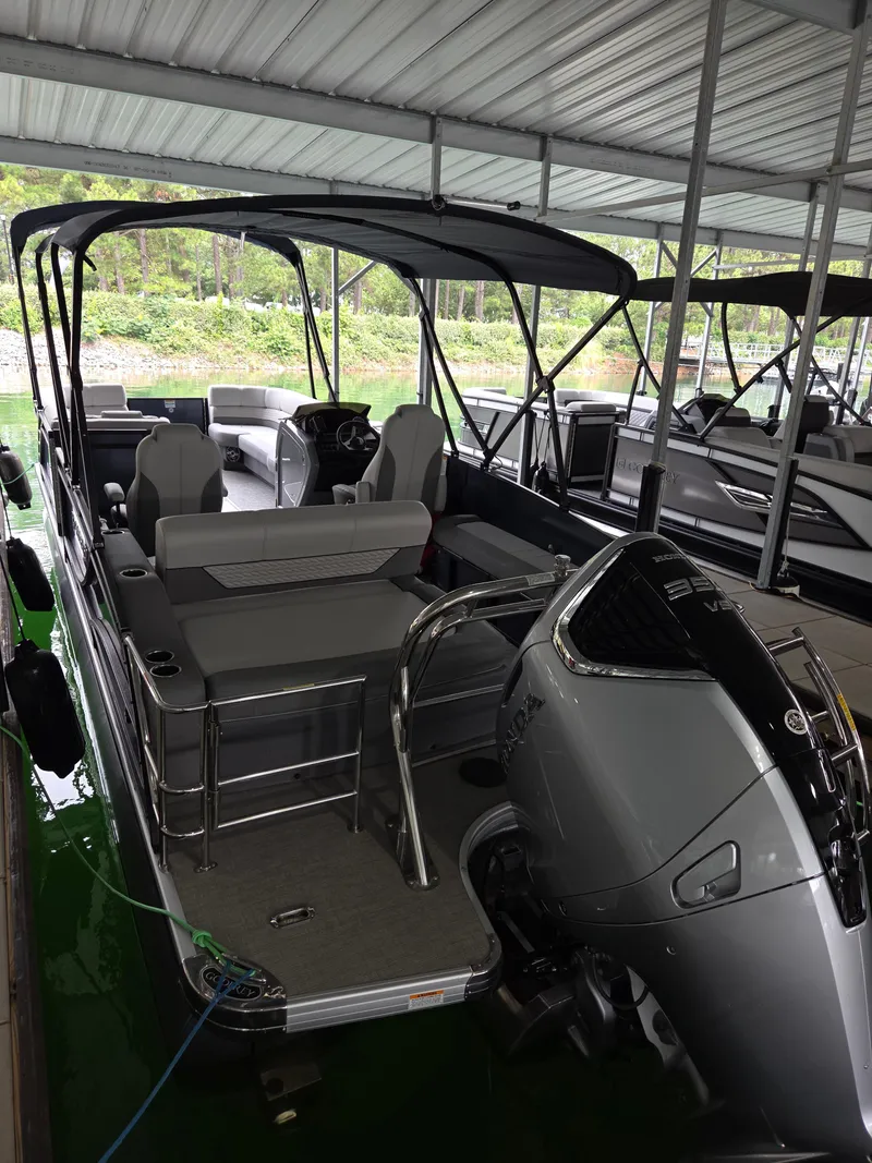 Slide: The Image of 2025 Godfrey Monaco 255 SFL pontoon boat docked under a covered marina. - 12