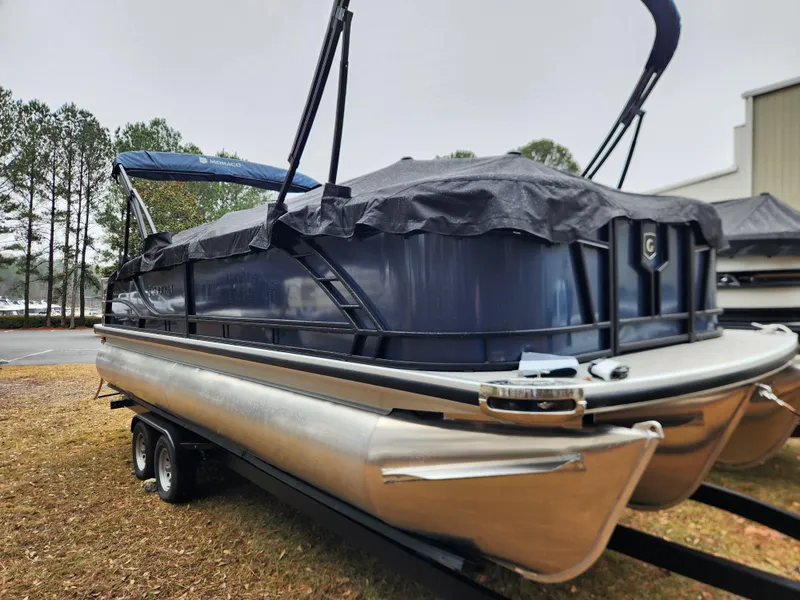 Slide: The Image of 2025 Godfrey Monaco 255 SFL pontoon boat on trailer, covered and parked outdoors. - 3