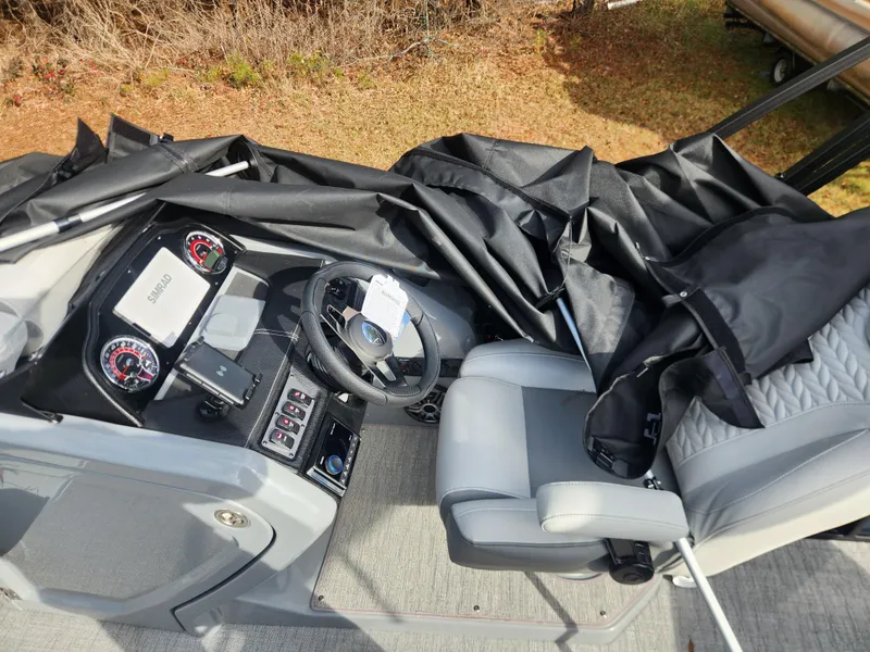 Slide: The Image of 2025 Godfrey Monaco 255 SFL boat interior with steering wheel and dashboard controls. - 7