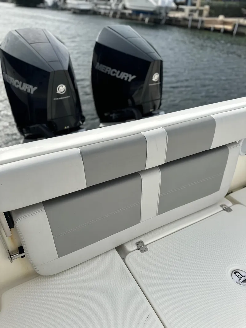 Slide: The Image of 2020 Mako 284 CC boat with dual Mercury engines on a waterfront. - 10