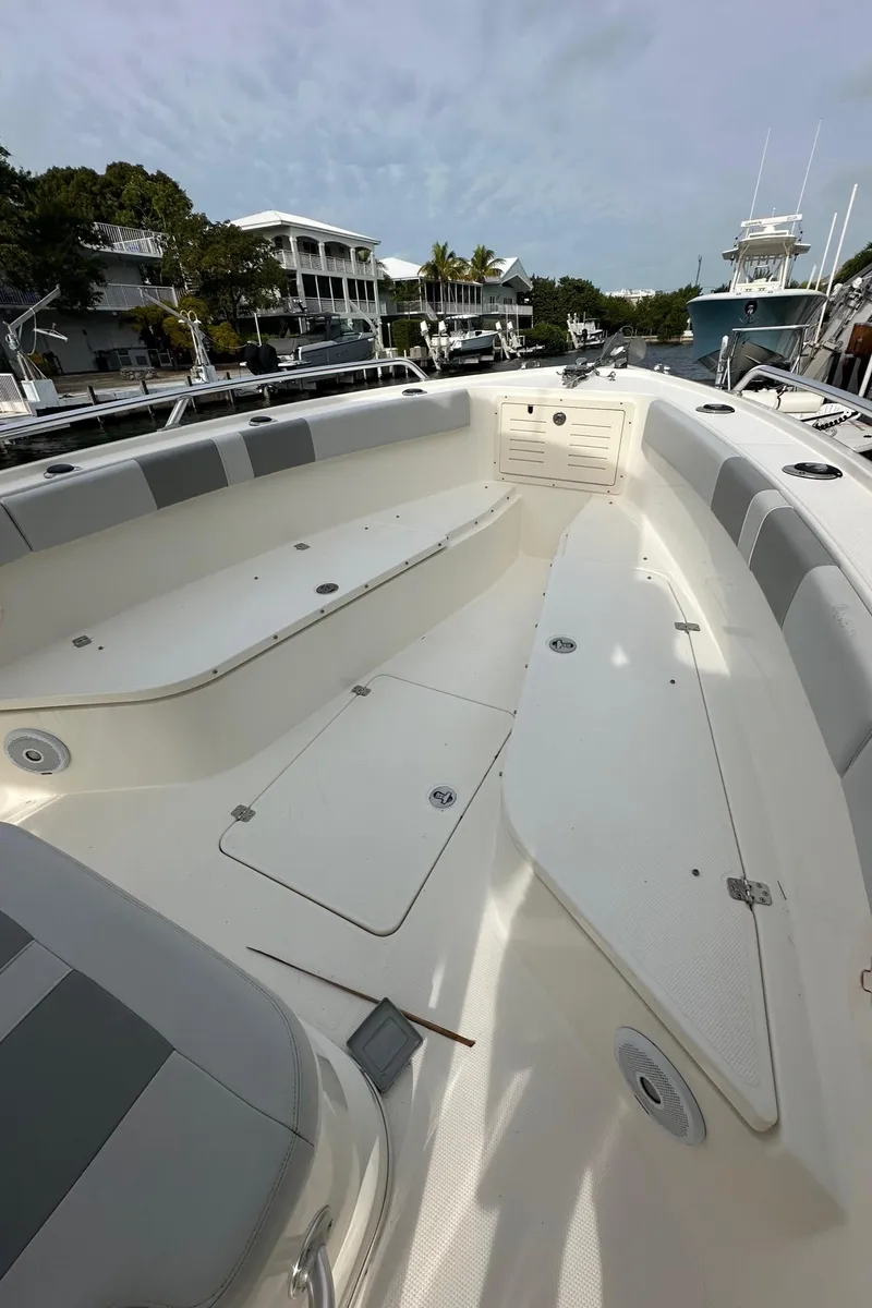 Slide: The Image of 2020 Mako 284 CC boat interior with spacious seating and storage, docked at marina. - 4