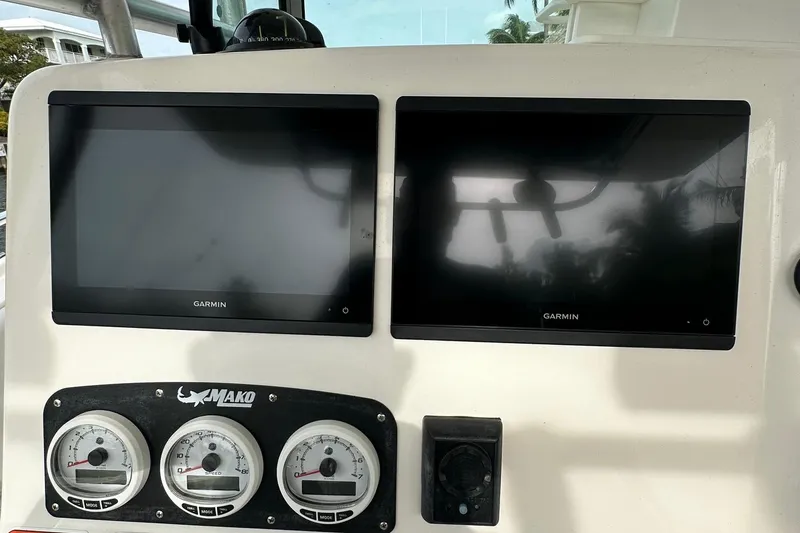 Slide: The Image of Mako 284 CC 2020 boat dashboard with Garmin displays and gauges. - 7
