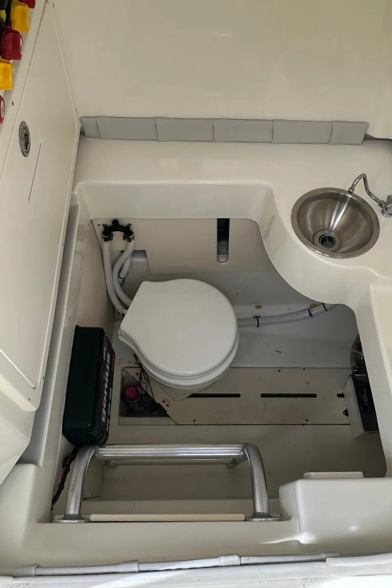 Slide: The Image of 2020 Mako 284 CC boat interior with toilet and sink. - 9