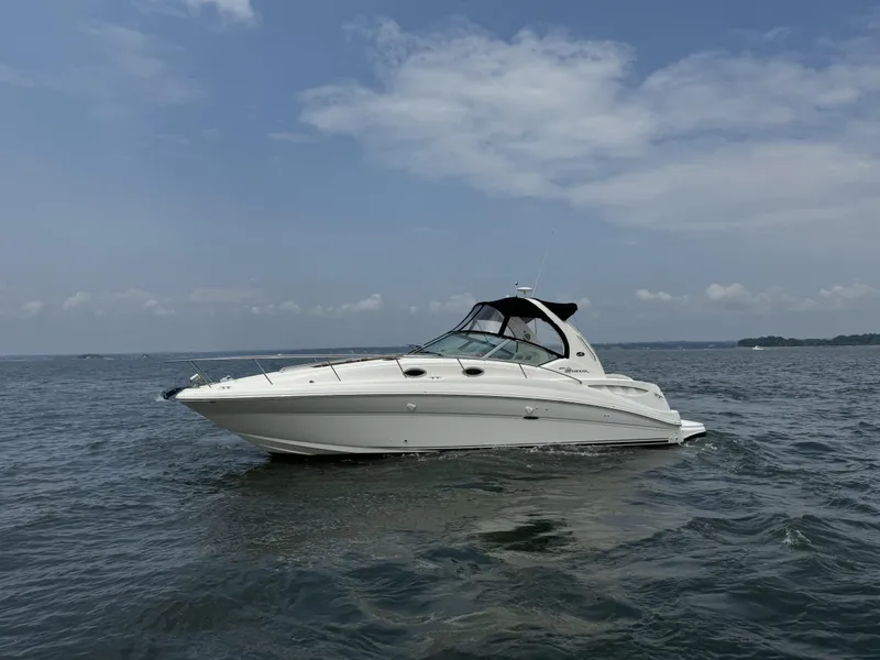 Slide: The Image of 2004 Sea Ray 320 Sundancer yacht cruising on open water under a clear sky. - 1