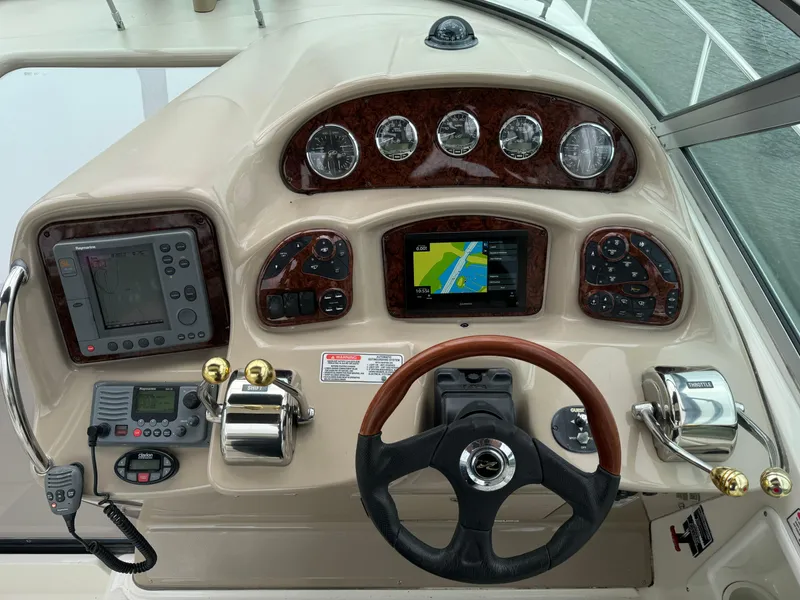 Slide: The Image of 2004 Sea Ray 320 Sundancer helm with navigation instruments and steering wheel. - 12