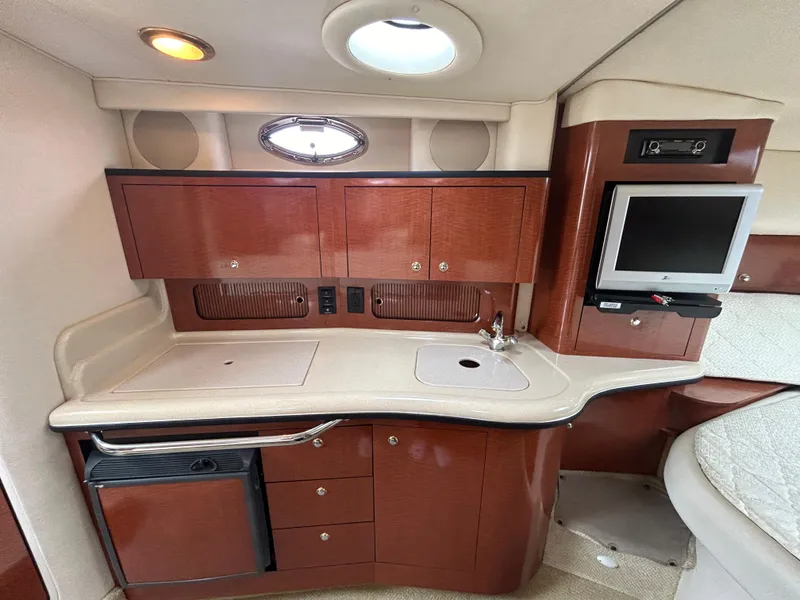 Slide: The Image of Luxurious 2004 Sea Ray 320 Sundancer cabin with kitchenette and TV. - 15