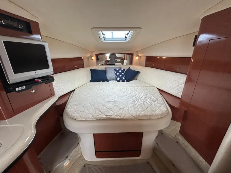 Slide: The Image of Luxurious cabin interior of 2004 Sea Ray 320 Sundancer with cozy bedding and TV. - 17
