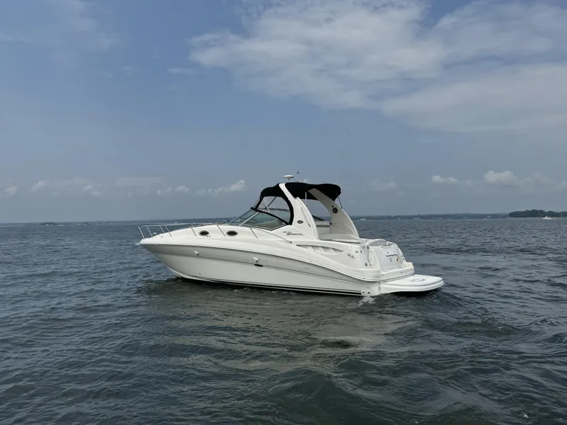 Slide: The Image of 2004 Sea Ray 320 Sundancer yacht on open water under a clear sky. - 2