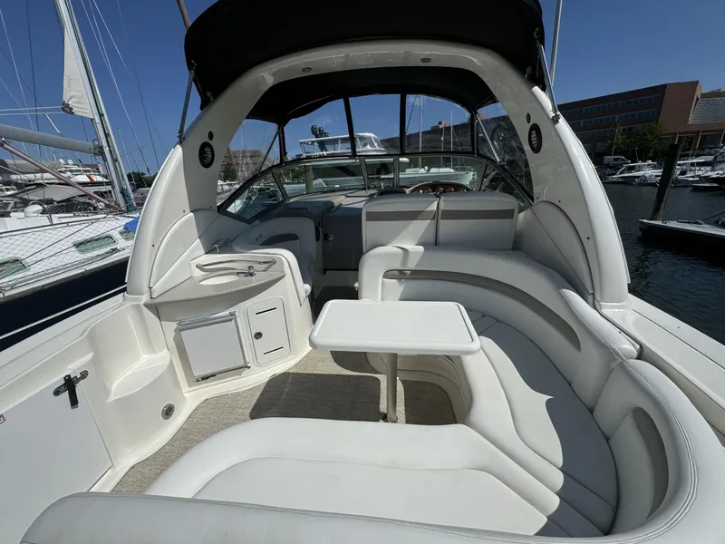 Slide: The Image of 2004 Sea Ray 320 Sundancer boat interior with white seating and table at marina. - 4