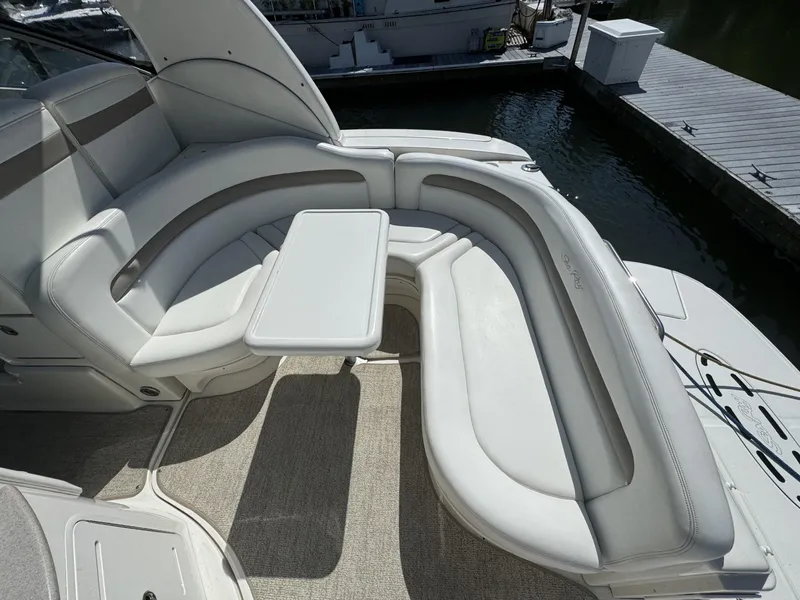 Slide: The Image of 2004 Sea Ray 320 Sundancer boat interior with curved seating and table. - 6