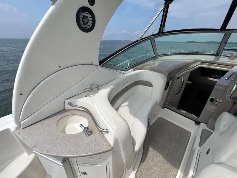 Slide: The Image of 2004 Sea Ray 320 Sundancer boat interior with seating and helm, on open water. - 7