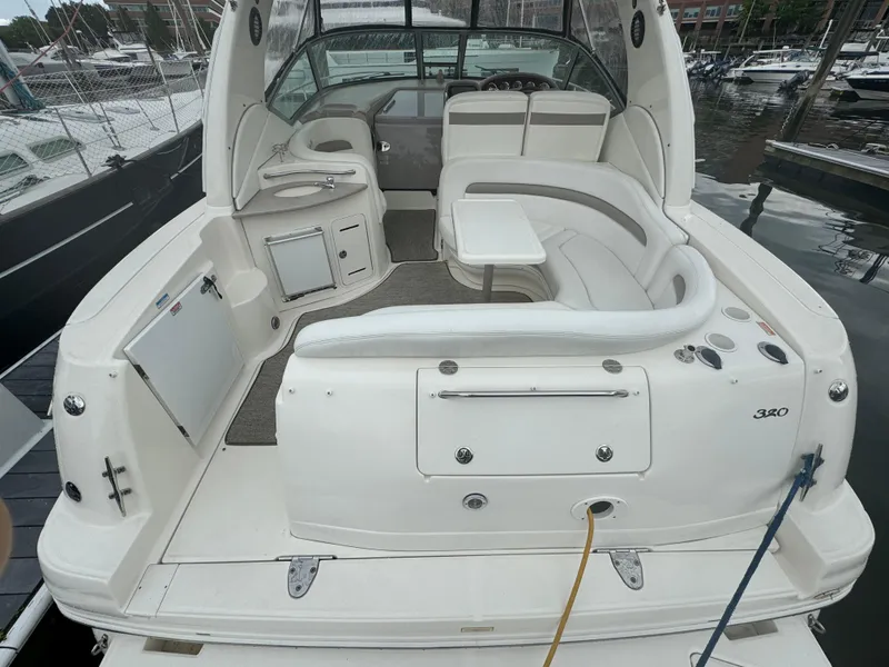 Slide: The Image of 2004 Sea Ray 320 Sundancer boat with spacious seating and modern amenities in a marina. - 8