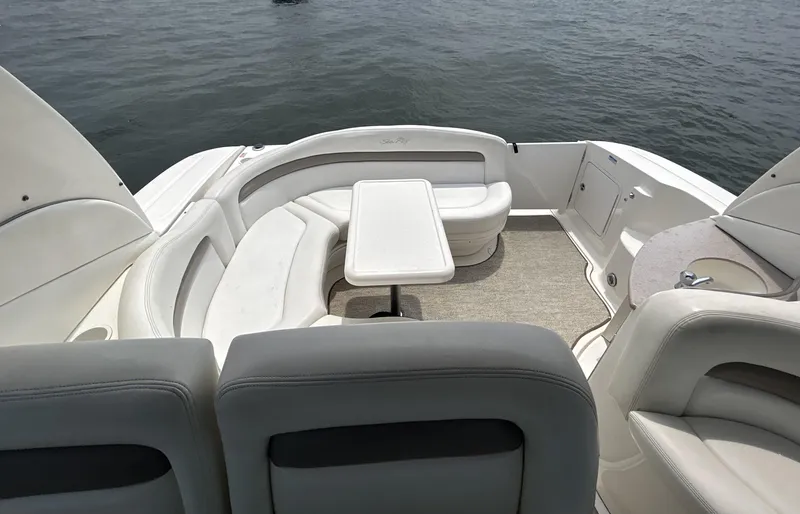 Slide: The Image of 2004 Sea Ray 320 Sundancer boat interior with seating and table on water. - 9