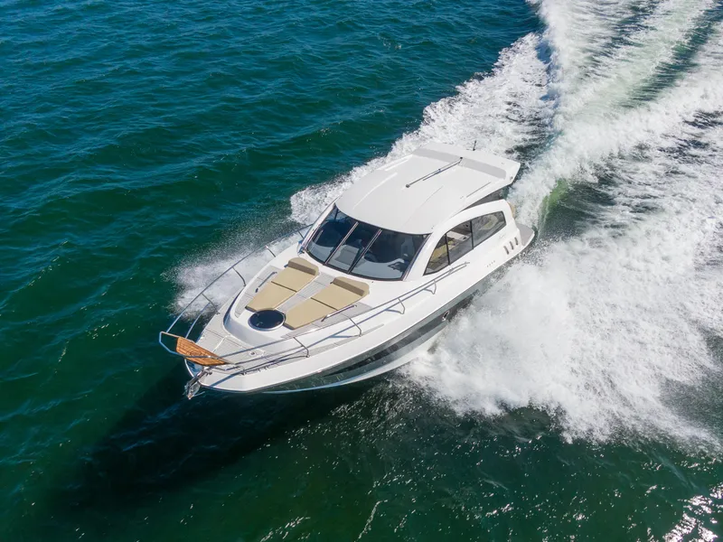 Slide: The Image of 2025 Hanover 375 Outboard cruising on open water, aerial view. - 2