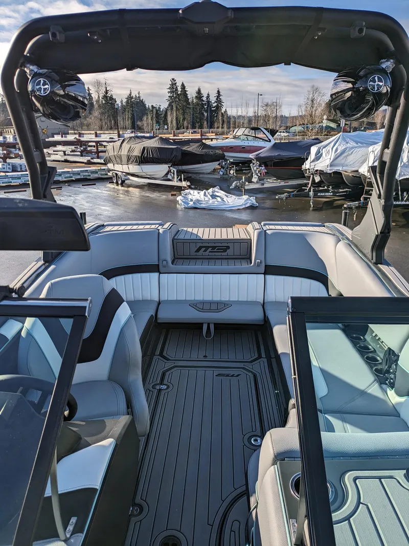 Slide: The Image of 2025 MB B52-21 Alpha boat interior at marina, featuring sleek seating and modern design. - 12