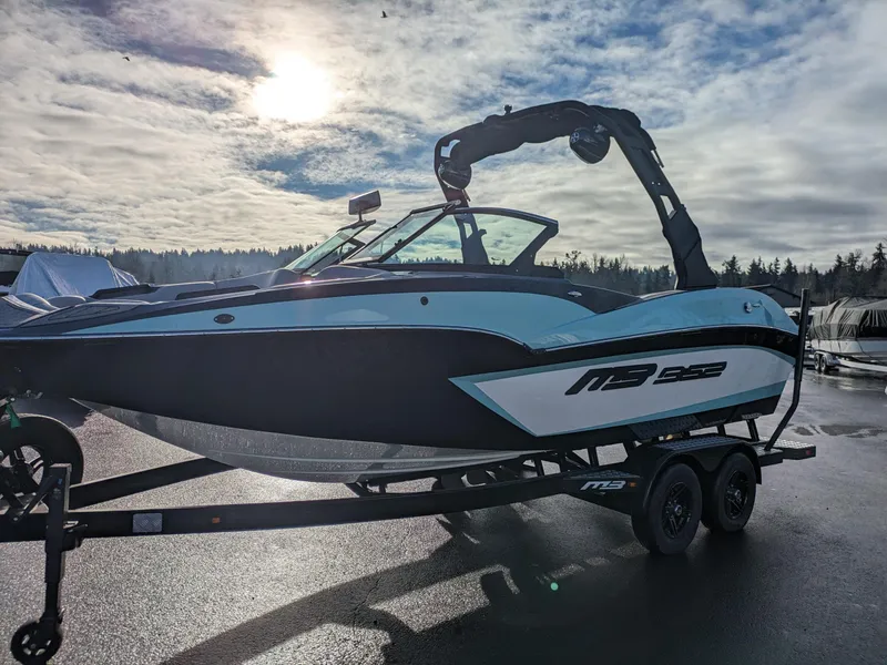 Slide: The Image of 2025 MB B52-21 Alpha boat on trailer under cloudy sky. - 2