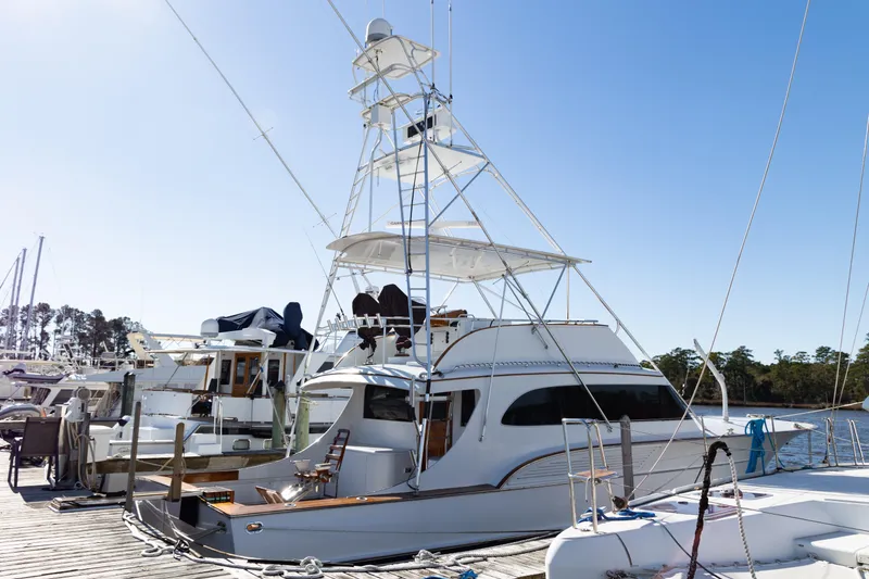 The Image of 1987 Buddy Davis 61 Convertible yacht docked at marina under clear blue sky. - 0