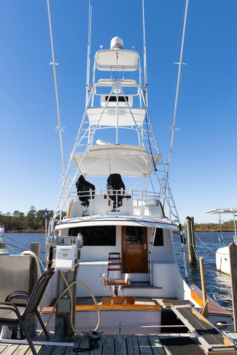 Slide: The Image of 1987 Buddy Davis 61 Convertible yacht docked, showcasing tall tower and clear blue sky. - 2