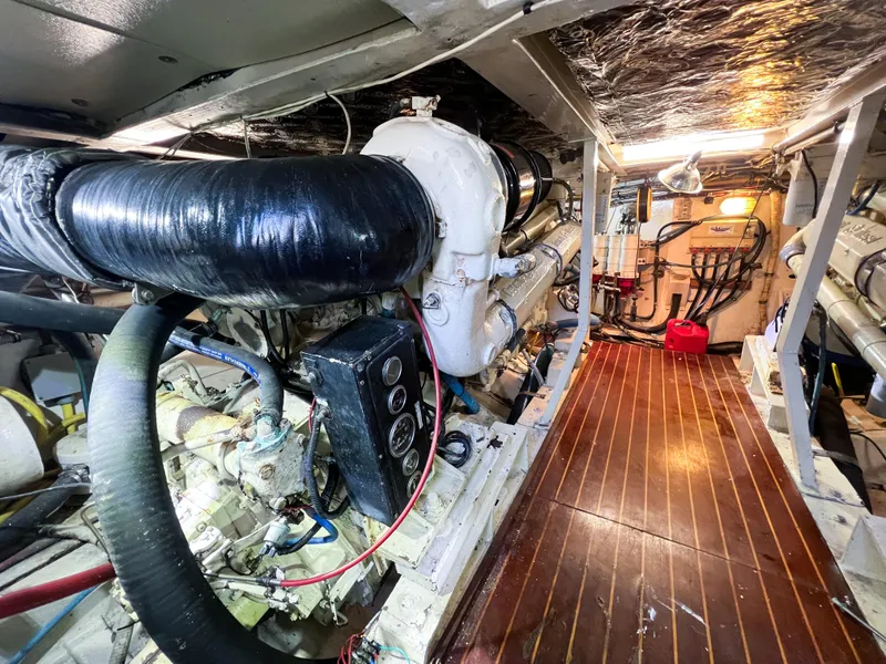 Slide: The Image of Engine room of a 1987 Buddy Davis 61 Convertible yacht, showcasing machinery and equipment. - 22