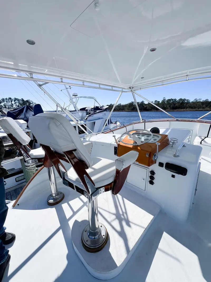 Slide: The Image of 1987 Buddy Davis 61 Convertible yacht helm with dual captain chairs and scenic water view. - 40