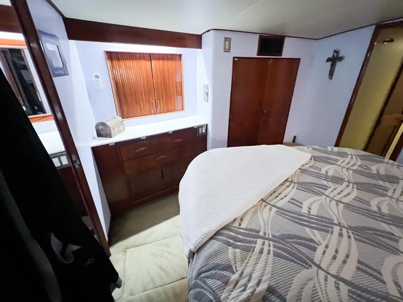 Slide: The Image of Interior of 1987 Buddy Davis 61 Convertible yacht, featuring cozy bedroom with wooden accents. - 47