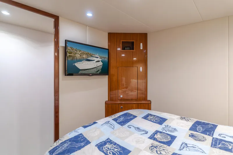 Slide: The Image of Interior of 2006 Hatteras 80 Motor Yacht bedroom with TV and patterned bedding. - 16