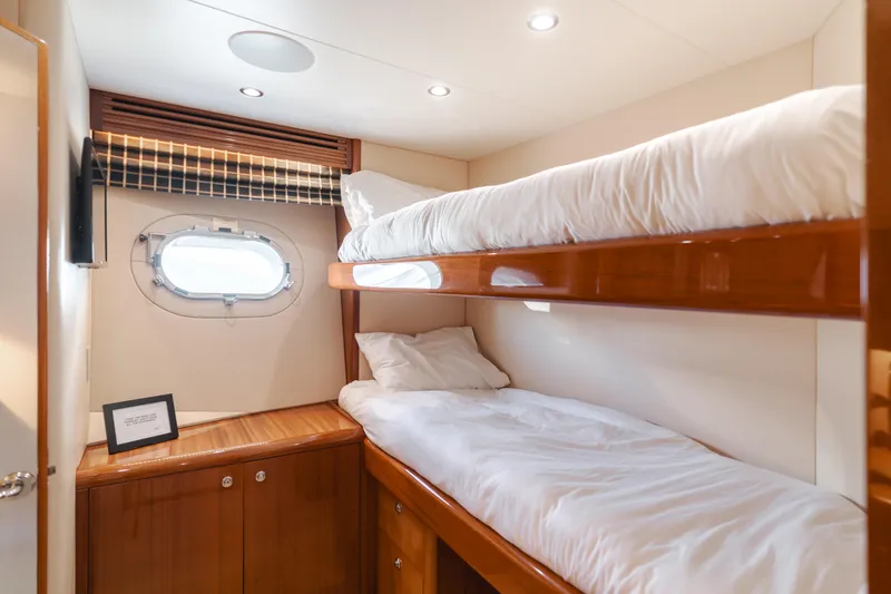 Slide: The Image of Bunk beds in 2006 Hatteras 80 Motor Yacht cabin with porthole and wooden cabinetry. - 32