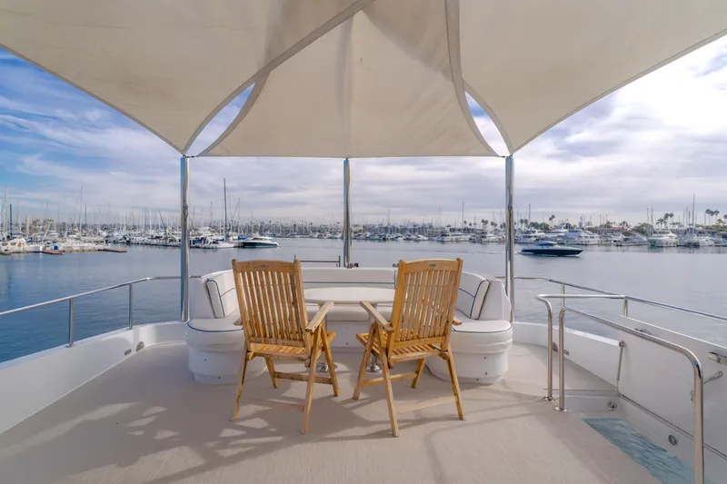 Slide: The Image of 2006 Hatteras 80 Motor Yacht deck with chairs, table, and marina view. - 46