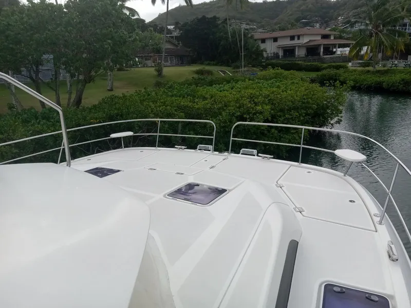 Slide: The Image of Aquila 44 yacht deck, 2016 model, overlooking lush greenery and waterfront homes. - 6